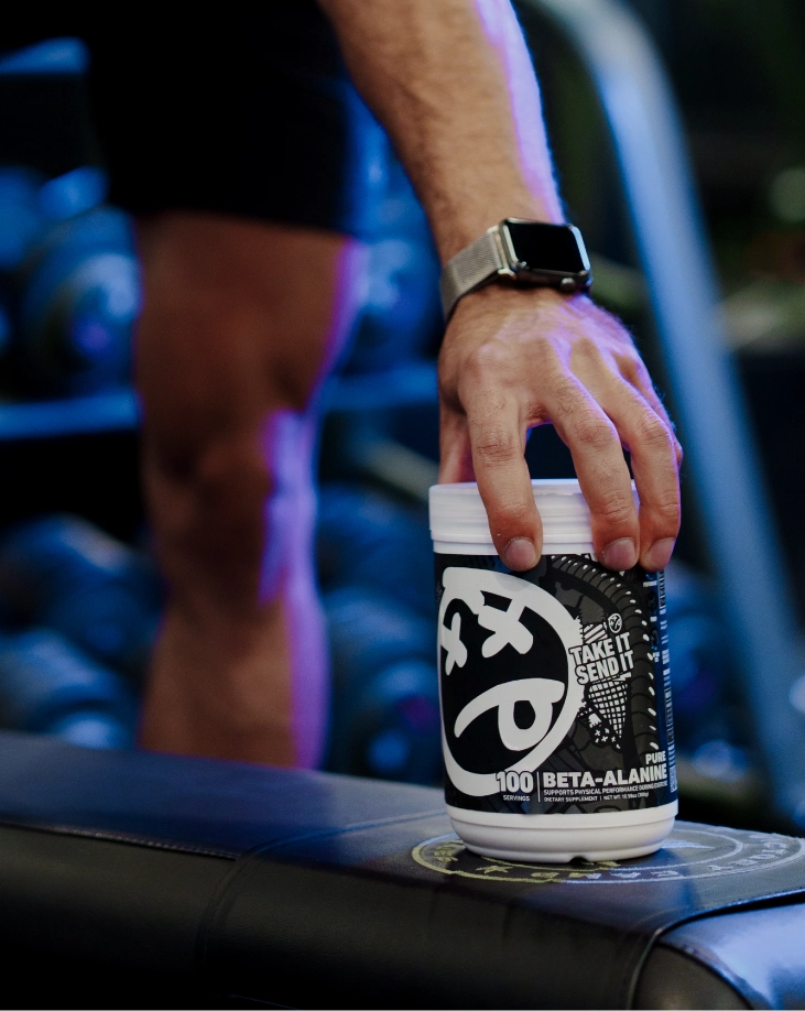 Athlete placing SKELETON® Beta Alanine supplement on gym bench before workout