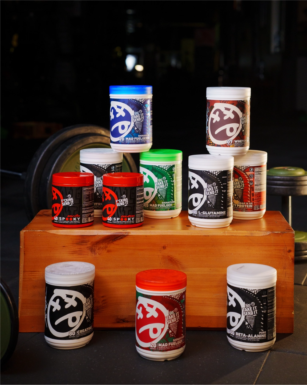 Assorted containers with different colored lids on a wooden block against a dark background