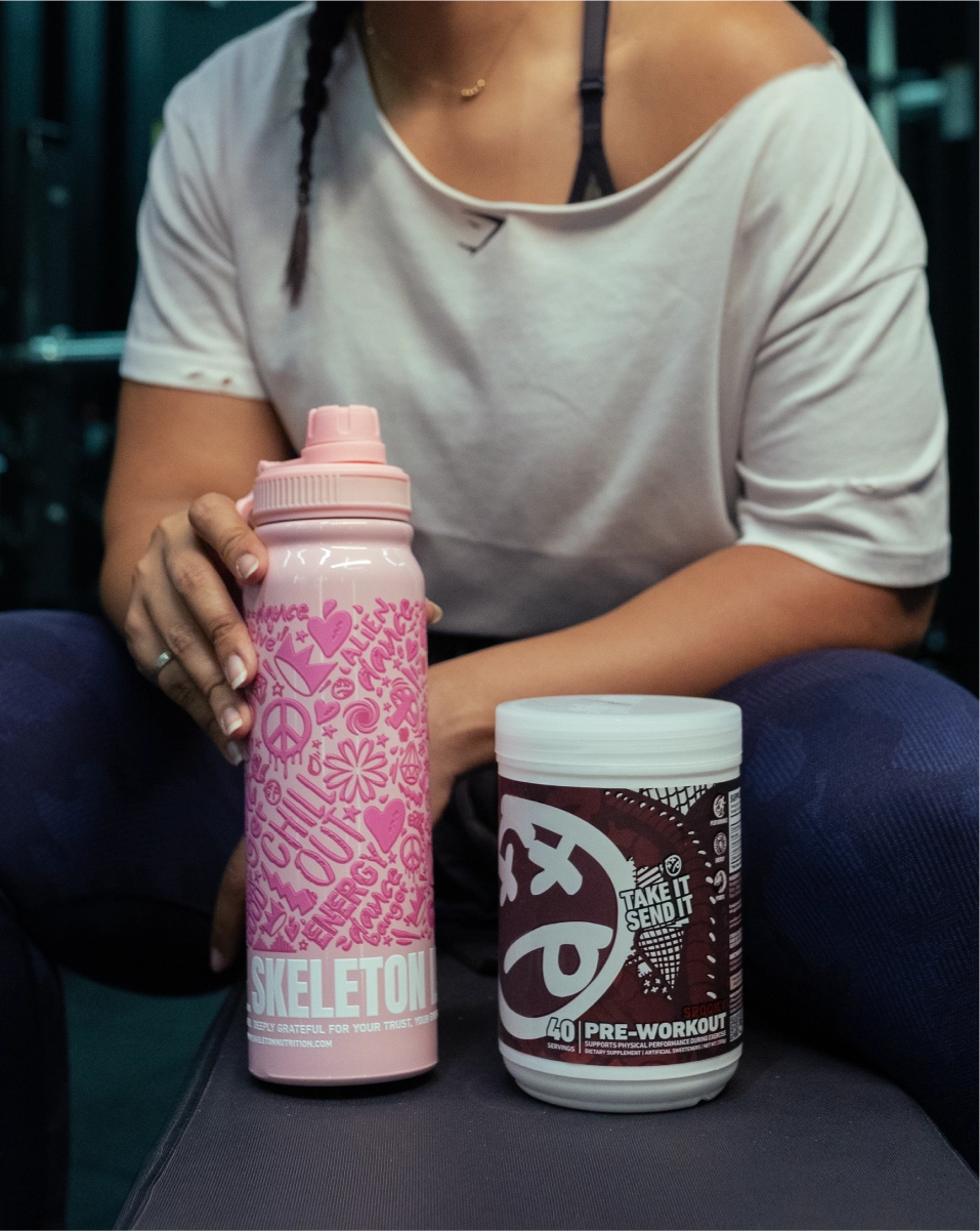 Woman with SKELETON® pre-workout supplement and shaker bottle before gym training session