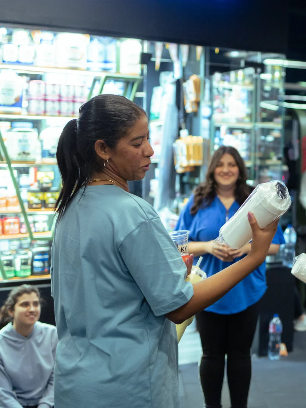 Person holding skeleton tattoo shaker in a store setting with shelves in the background